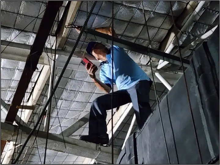 วิศวกรปีนตรวจสอบโครงเหล็กใต้หลังคาเพื่อคํานวณแผงโซล่าเซลล์ JNP Construction